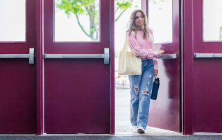 student walking through school doors